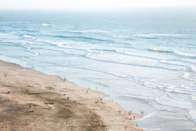 Plage de sable avec promeneurs et vagues océaniques